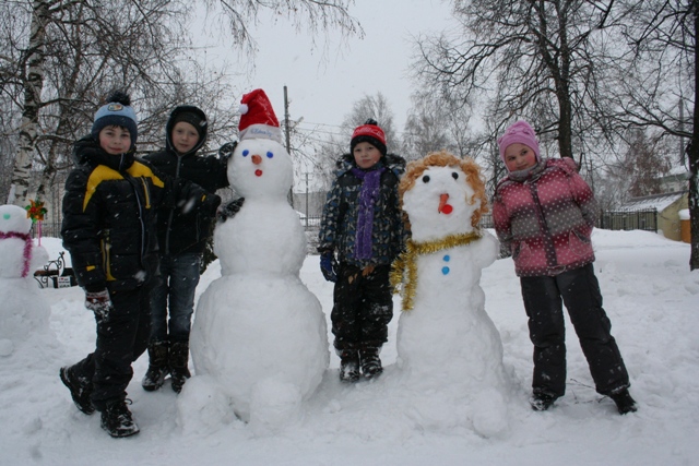 Мужчина лепит снеговика фото